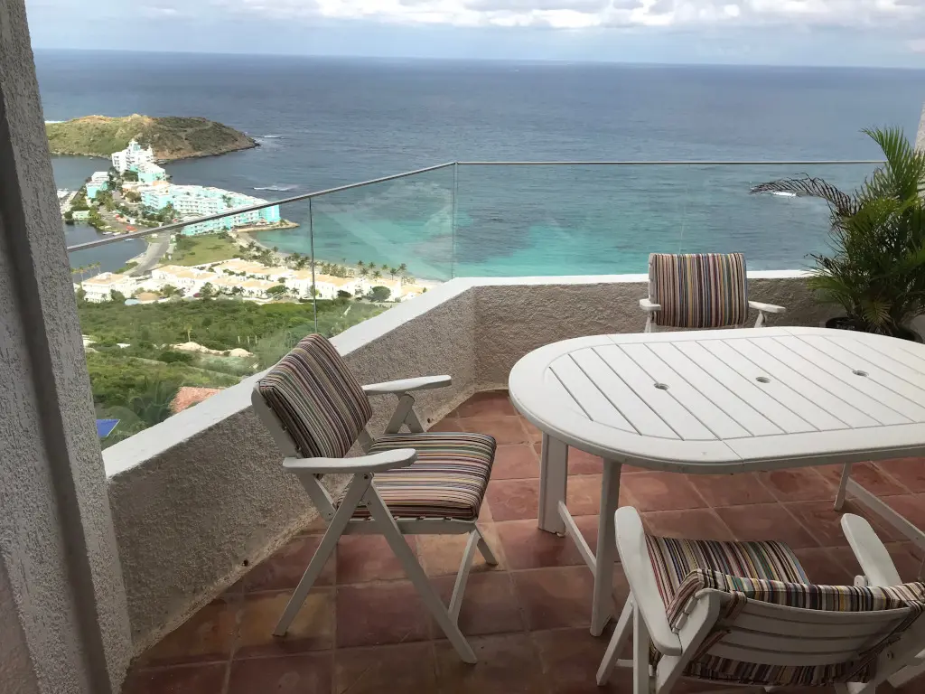 Morning coffee or evening wine — your glass-railed balcony looks out over the turquoise sea.