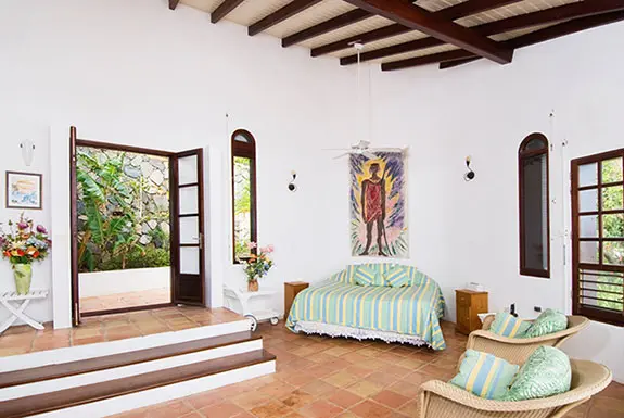 Daybed, wicker chairs, and open doors to the sea — this is where you'll read, nap, and lose track of time.