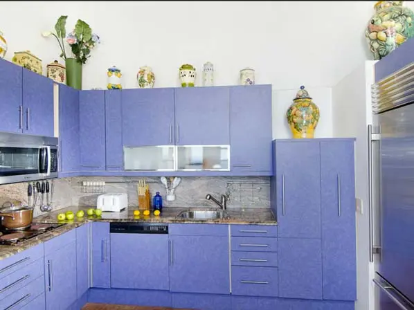 A chef's kitchen in Caribbean colors — granite counters, stainless appliances, and lavender cabinets make cooking a joy.