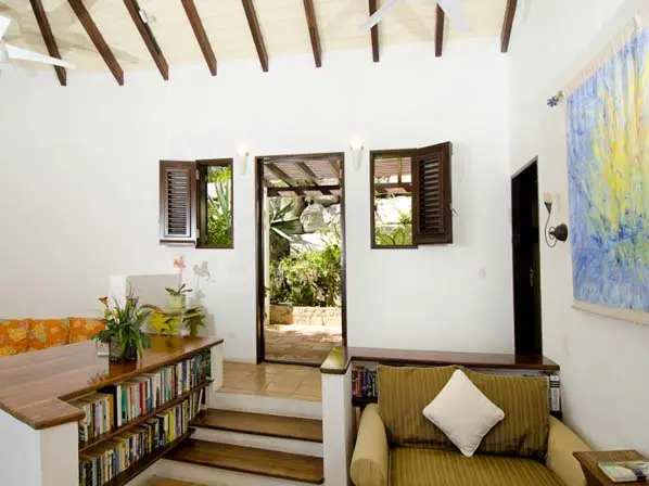 Vaulted beams, art, and an open doorway to the terrace — living spaces that breathe island life.