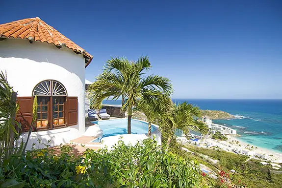Lounge by the pool with the ocean stretching before you — the quintessential St. Maarten escape.
