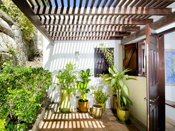 Cool stone and dappled shade frame the transition from tropical garden to your villa's welcoming interior.