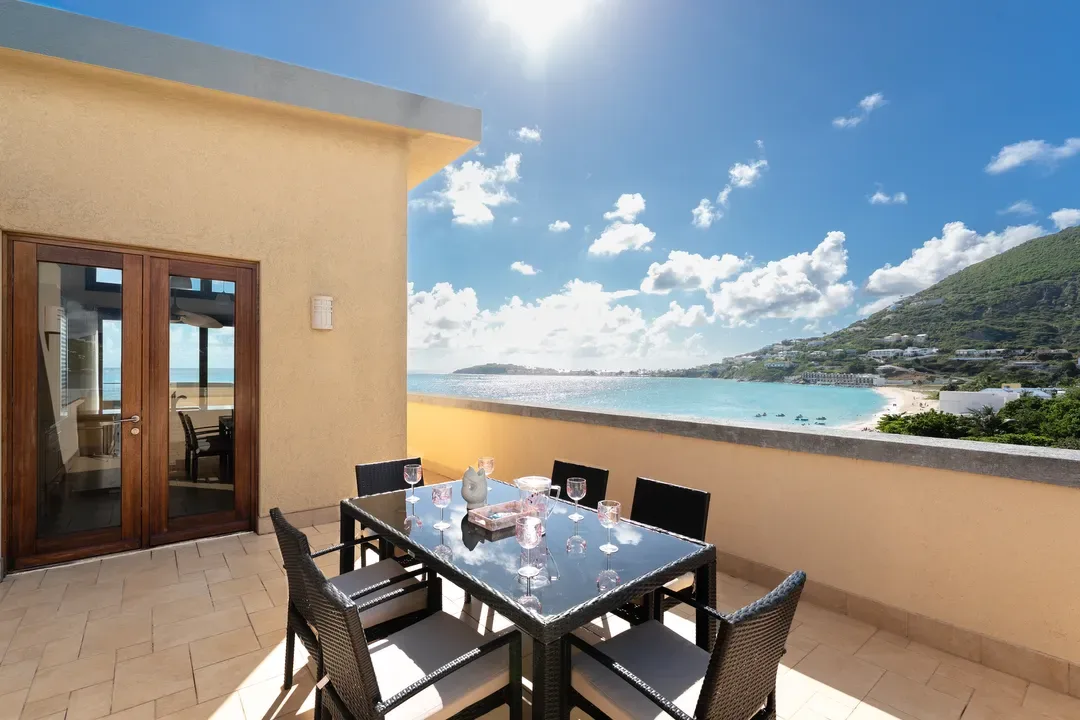 Entertain with style — a glass-top terrace dining table set for six, with panoramic ocean views as your backdrop.