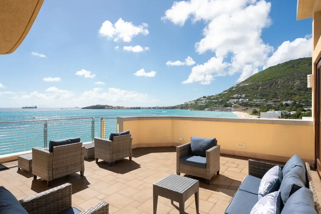Lounge in style on your expansive terrace — wicker furnishings, ocean breezes, and the perfect sunset view over Great Bay.
