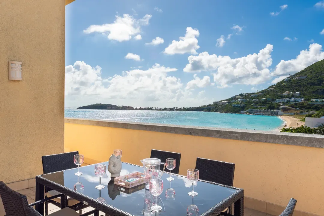 Wine and dine overlooking the bay — a romantic terrace setting with sculptural decor and the Caribbean Sea stretching to the horizon.