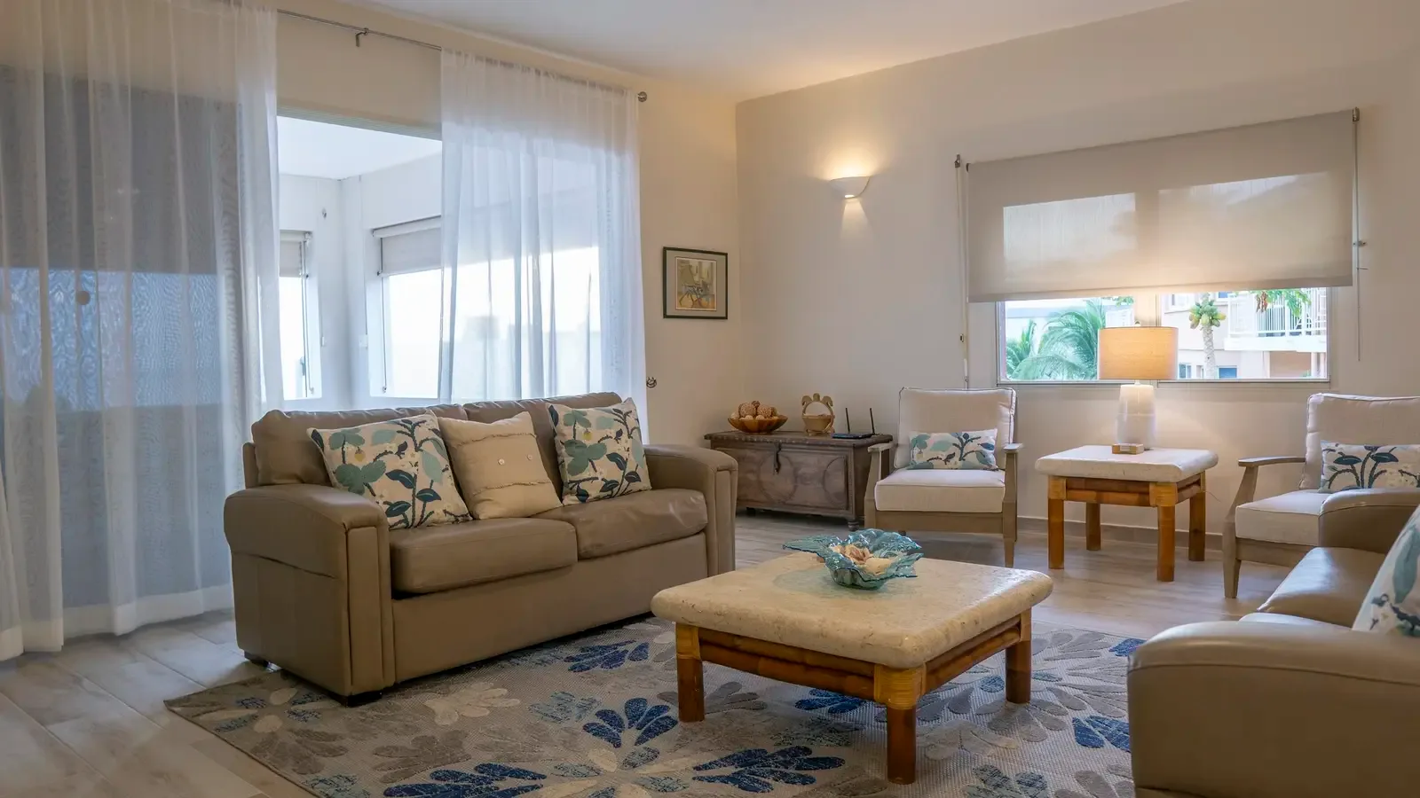 Sun-drenched living room with leather sofas — your spot for afternoon reads and island naps.