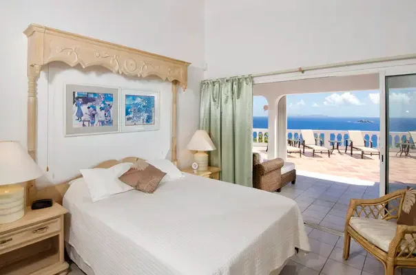 Airy bedroom opening to the terrace with panoramic ocean views.