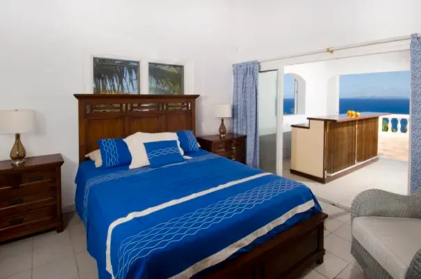 Guest bedroom with direct terrace access and an easy indoor-outdoor island vibe.