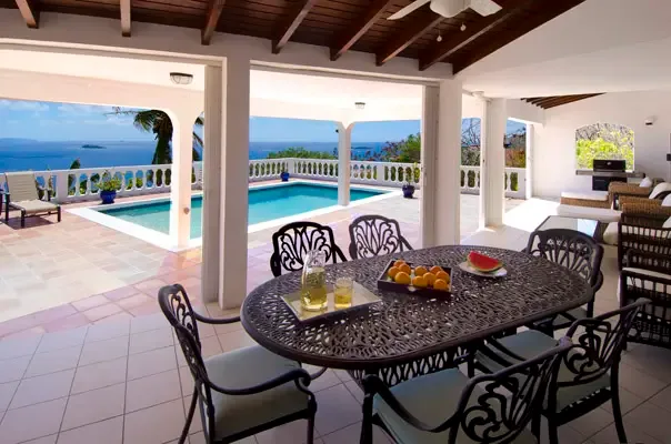 Covered dining terrace overlooking the pool and ocean for effortless indoor-outdoor living.