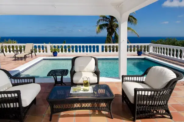 Covered terrace lounge opening to the pool deck with open Caribbean views.