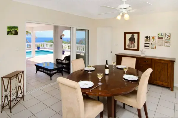 Elegant dining room with terrace access and ocean views beyond the pool deck.