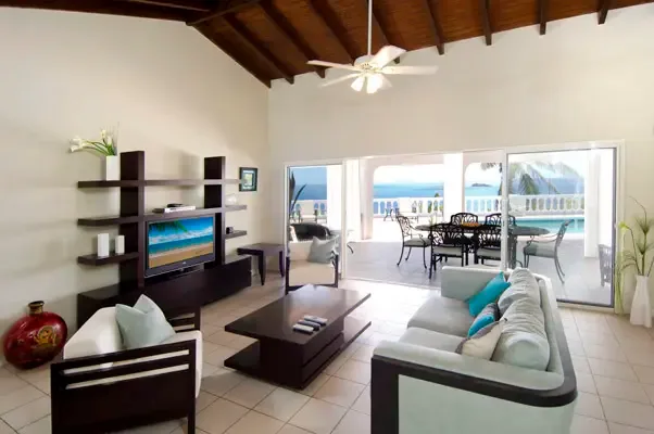 Open-concept living area with pool and ocean views framed by large glass doors.