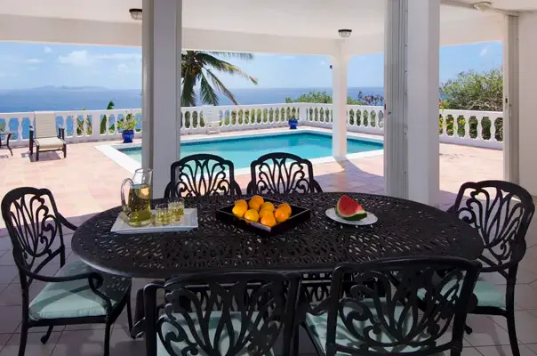 Outdoor dining area overlooking the pool and ocean, made for long Caribbean lunches.