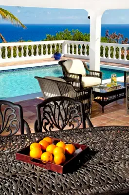 Terrace dining detail overlooking the pool and ocean, perfect for laid-back island meals.