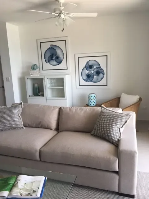 Coastal charm meets modern comfort in this inviting sitting area — nautical art accents remind you that the ocean is just steps away.