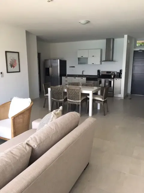 The heart of the villa: an airy, open-concept living space where kitchen, dining, and lounge areas connect seamlessly to the outdoor terrace and pool.