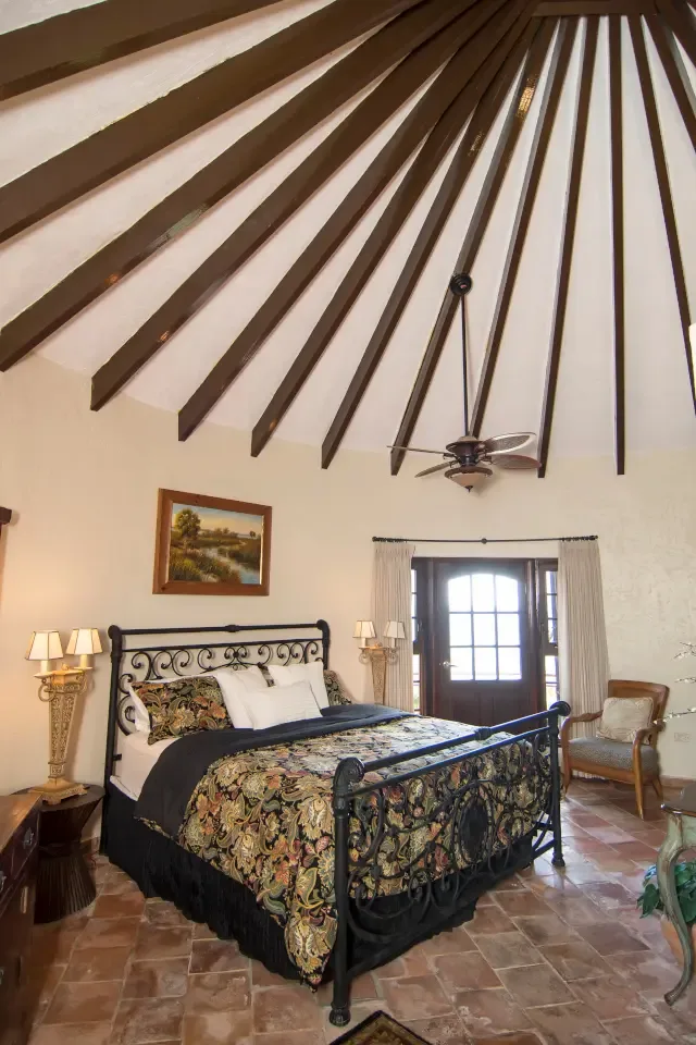 Sleep beneath a stunning conical ceiling with radiating wooden beams — architecture meets comfort.