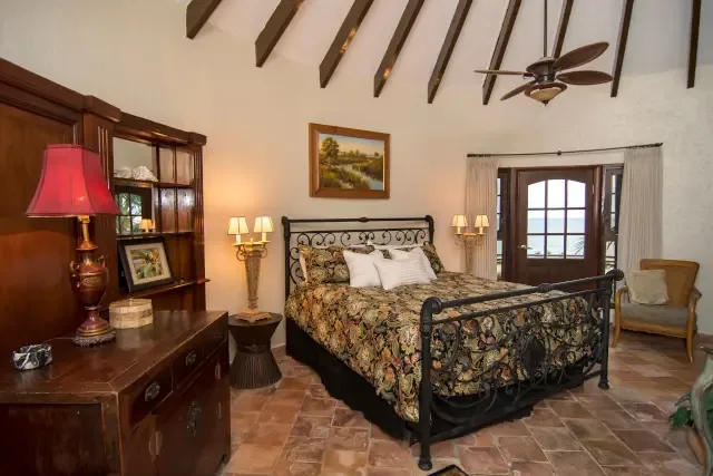 A grand vaulted ceiling with exposed beams — your spacious bedroom retreat feels like a Mediterranean villa.