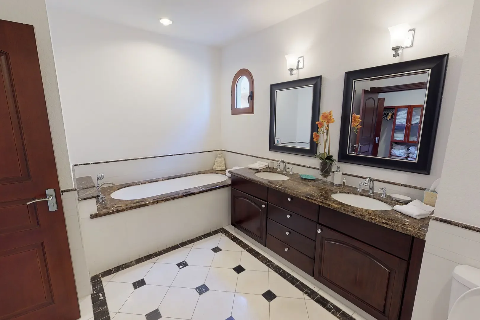 The spacious master bathroom features a double vanity with dark wood cabinetry, granite countertops, and built-in soaking tub with matching marble surround.