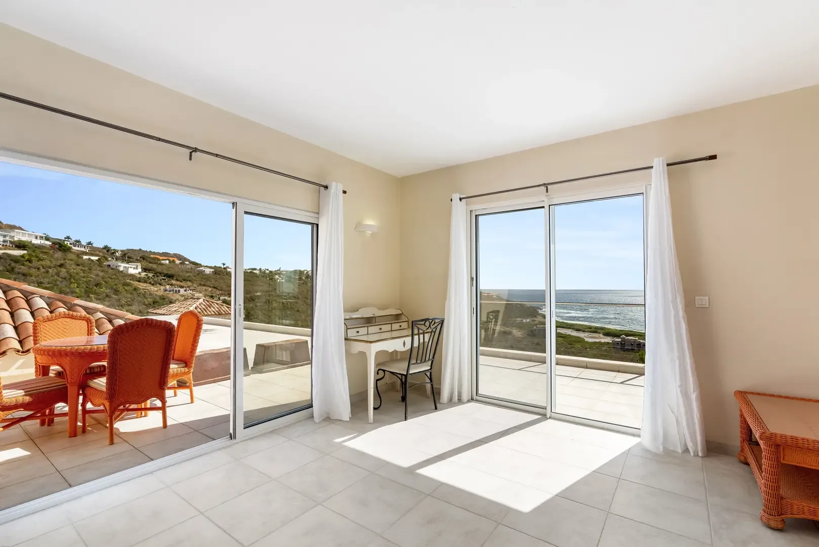 A sunlit room opens to terrace — indoor-outdoor living with ocean views.