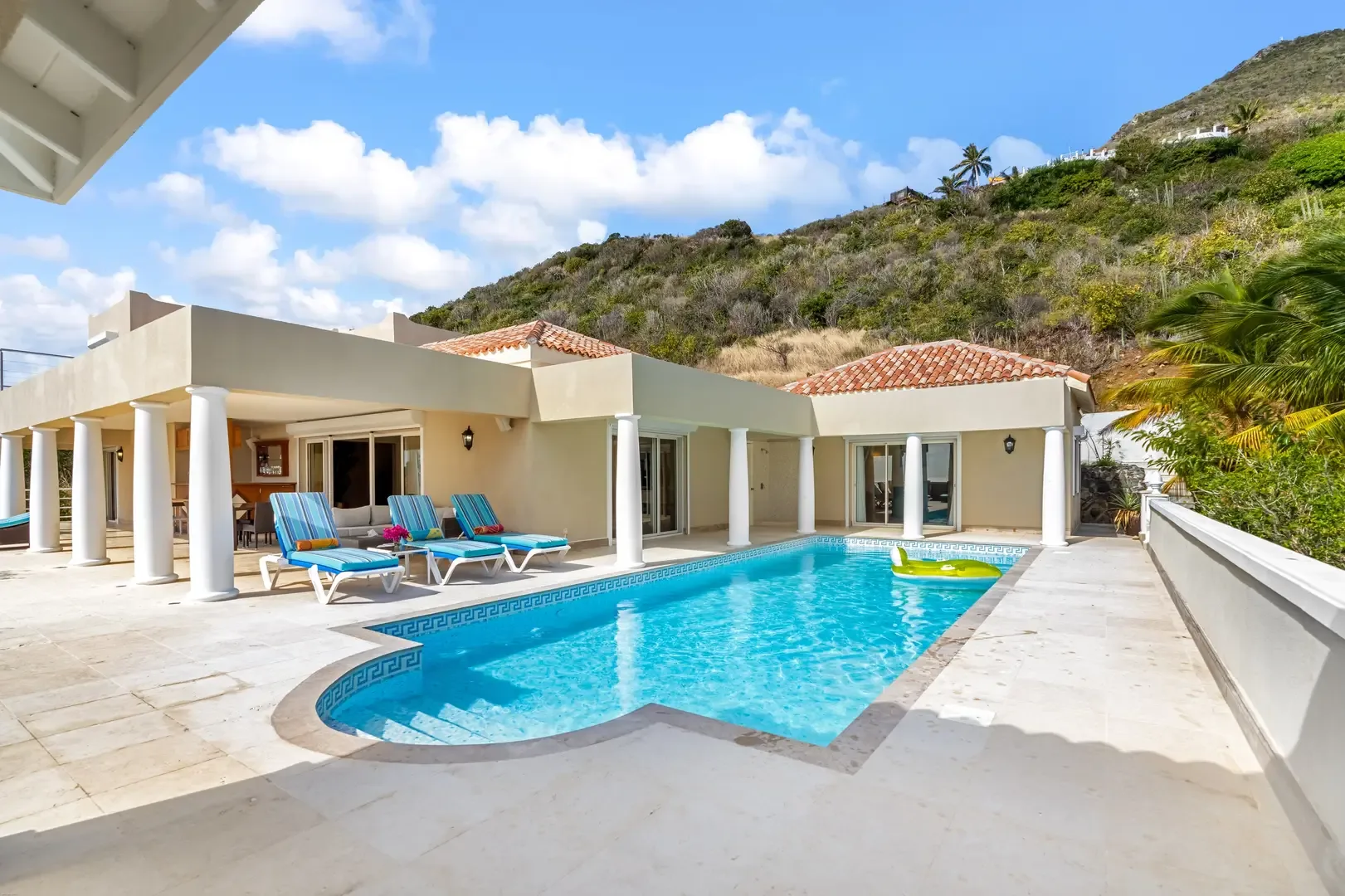 A curved pool with Greek-key tile detail — the heart of your outdoor living space.
