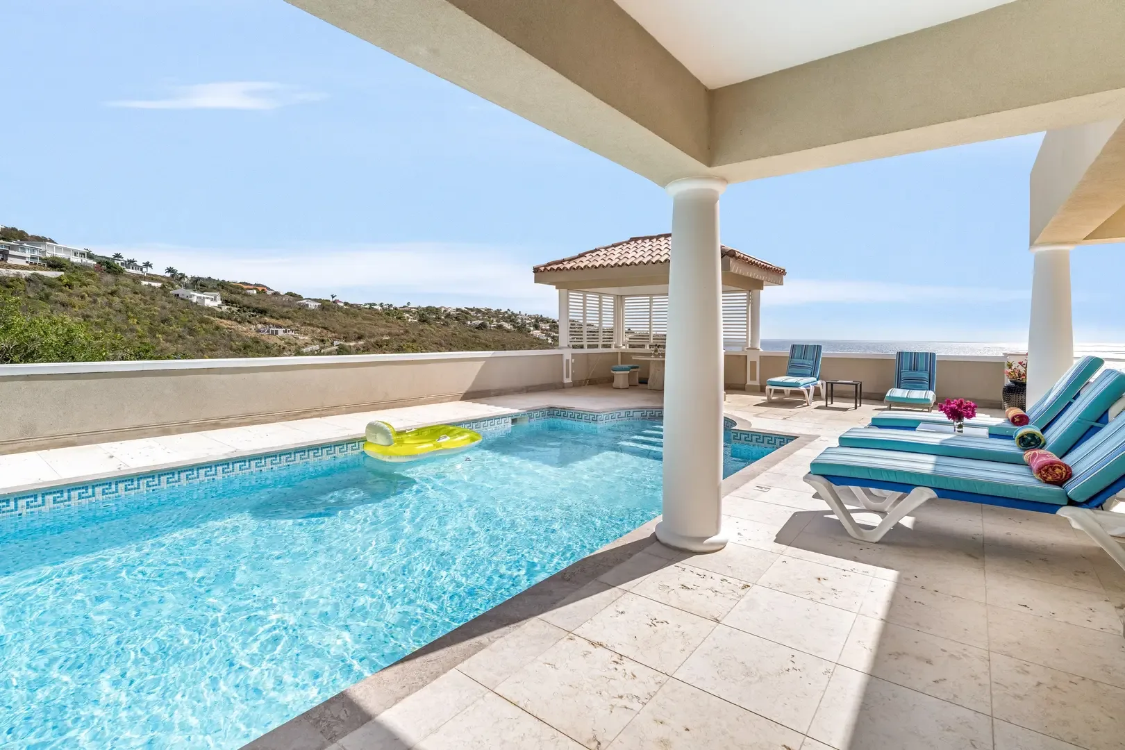 Lounge chairs by the pool with ocean views — your private Caribbean retreat.