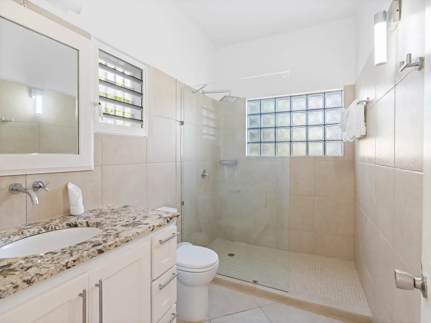 Refresh in your walk-in glass shower after a day at the beach — clean lines and bright finishes for effortless relaxation.