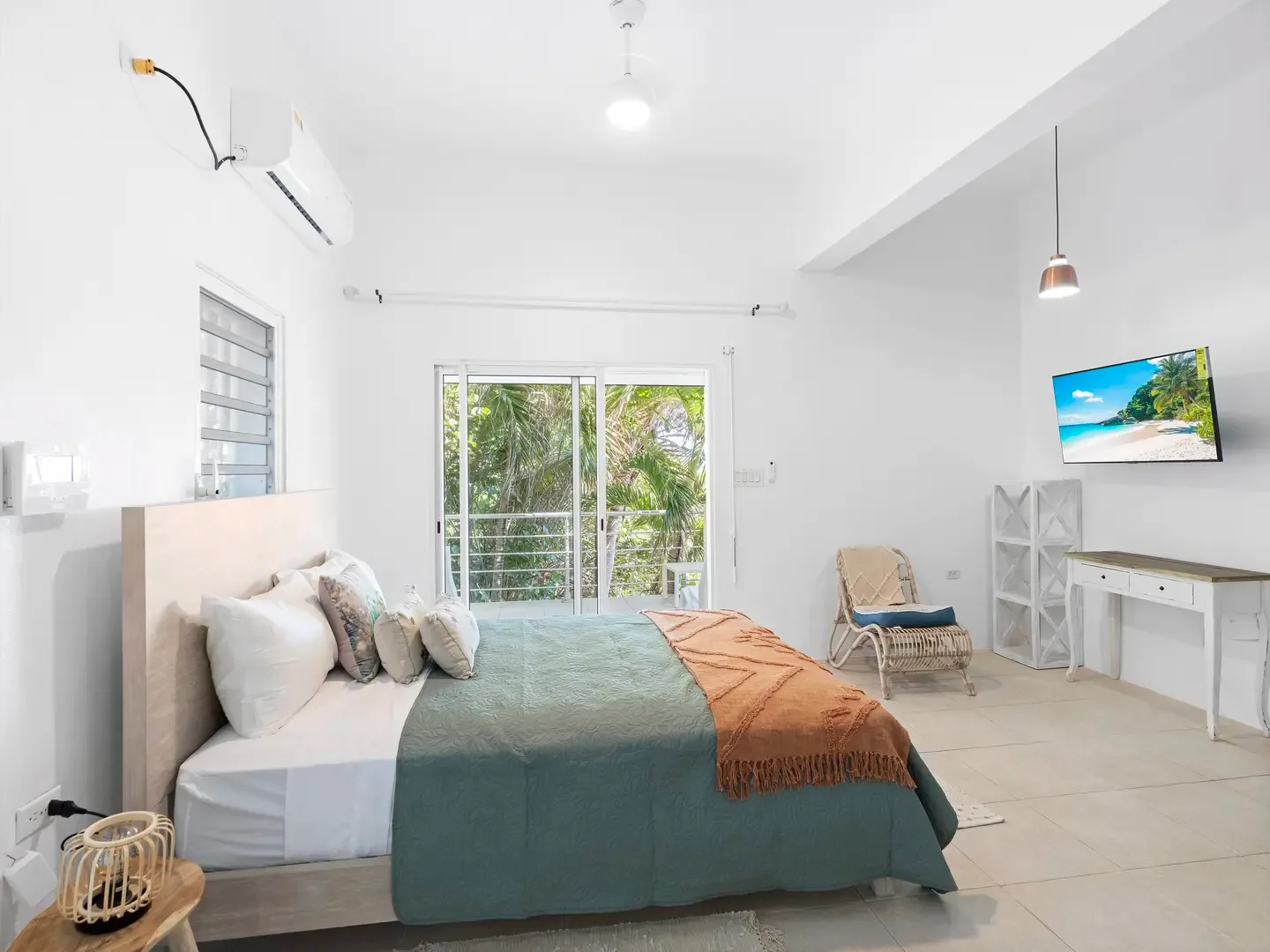 A quiet retreat with garden views, where teal linens and wicker accents capture the essence of Caribbean living.