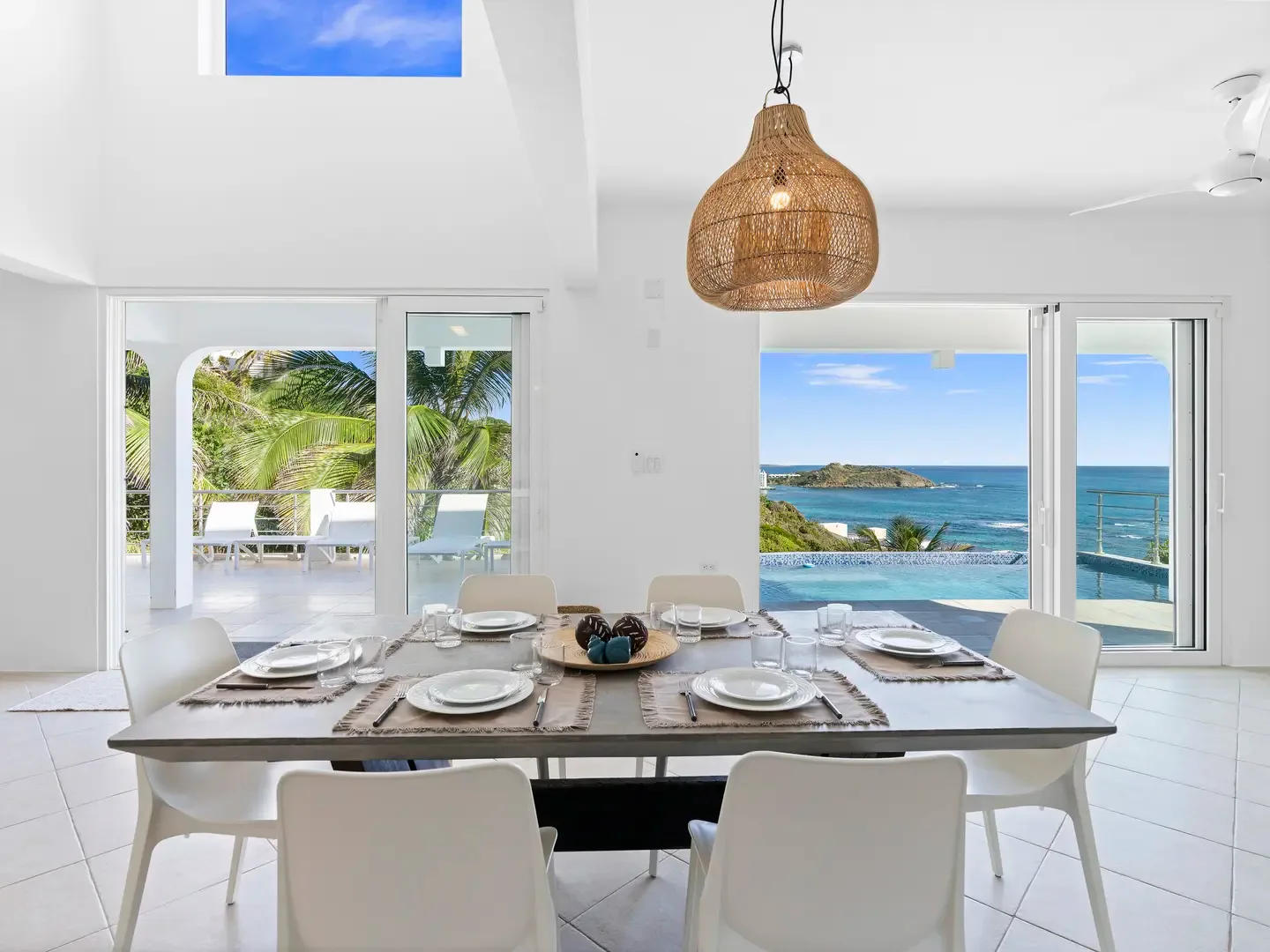 Gather around the dining table as sunlight streams through the skylight and the ocean sparkles just beyond your glass doors.