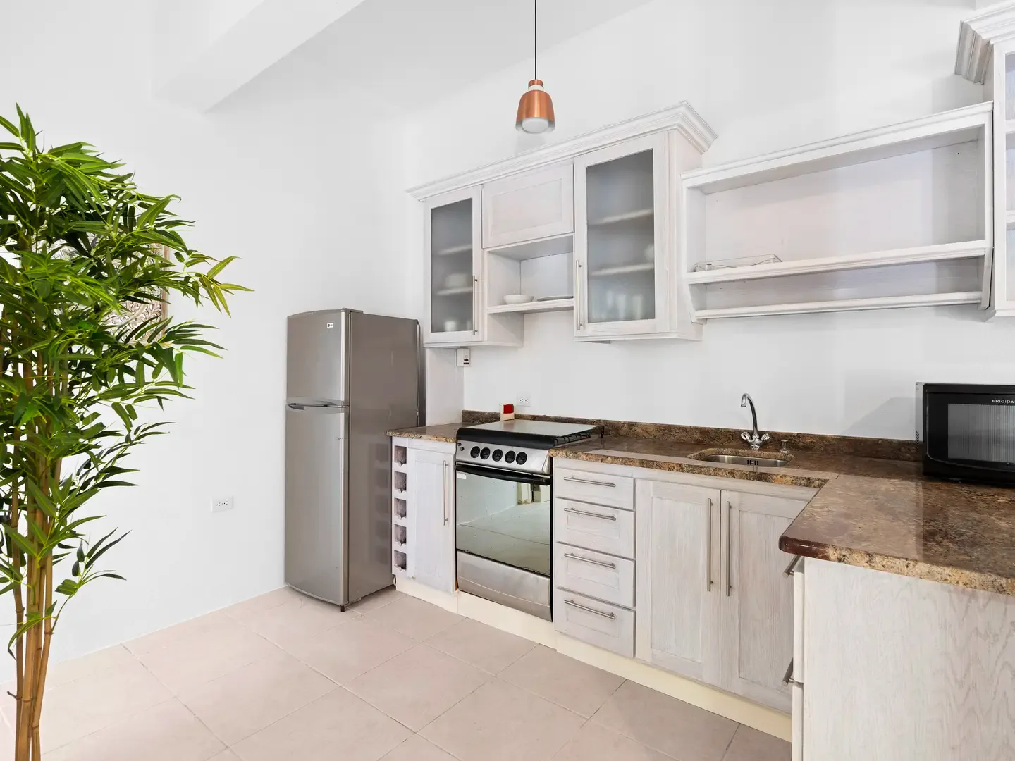 A well-appointed kitchen with wine rack and copper pendant lights — the perfect setting for crafting vacation cocktails.