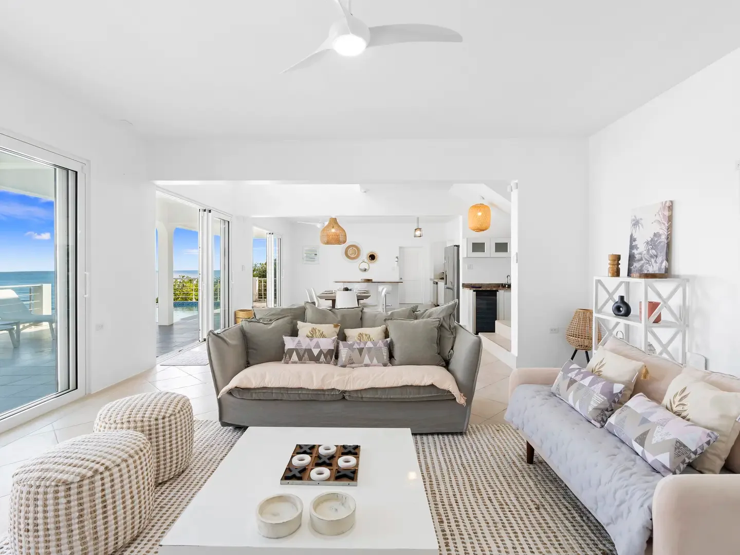 Sink into plush sofas in your open-concept living space, where every glance reveals palm trees and ocean blue.