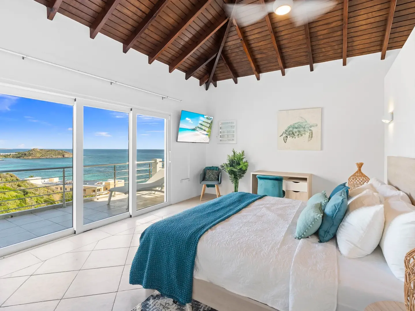 Wake up to ocean vistas from your master suite, where vaulted ceilings and teal accents create a serene tropical retreat.