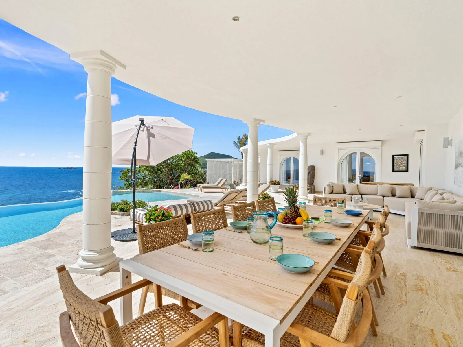 Covered terrace with outdoor dining and ocean views