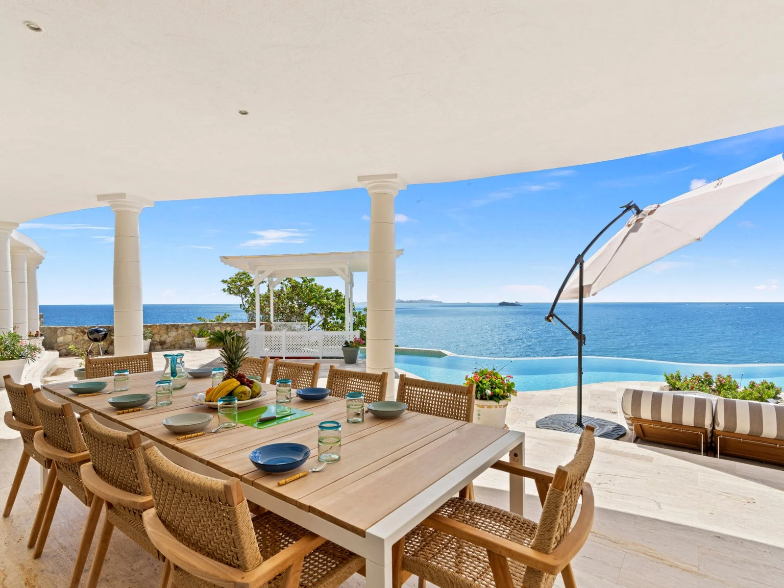 Covered terrace with outdoor dining and ocean views