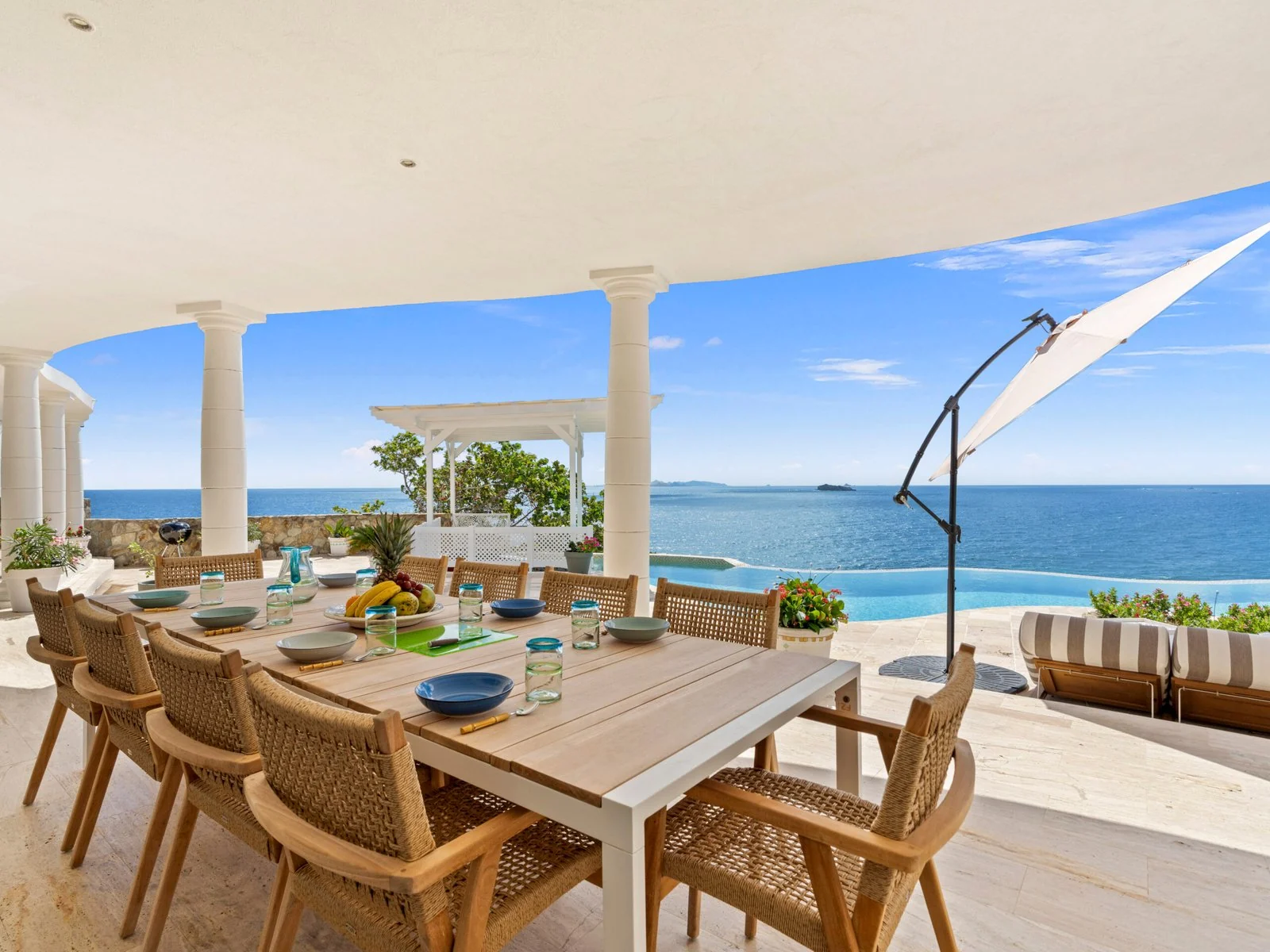 Covered terrace with outdoor dining and ocean views