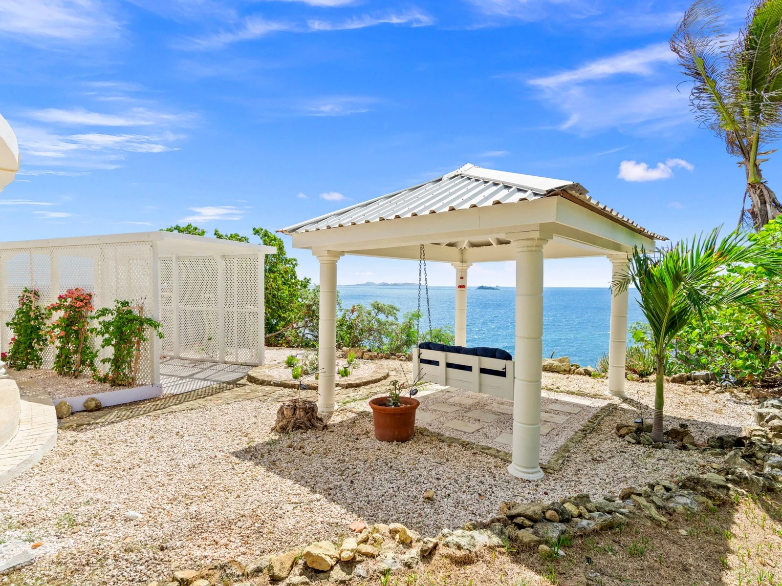 Garden gazebo with swinging bench and ocean views