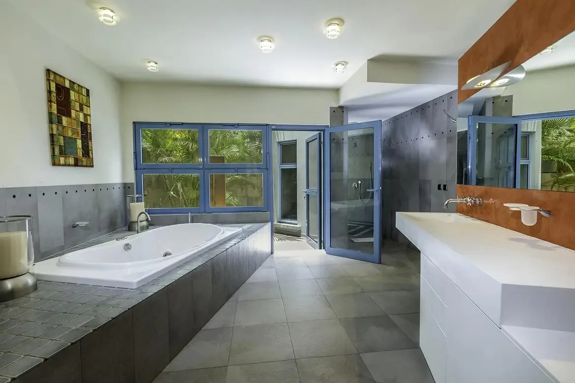 Blue-framed windows frame lush views from your luxurious soaking tub.