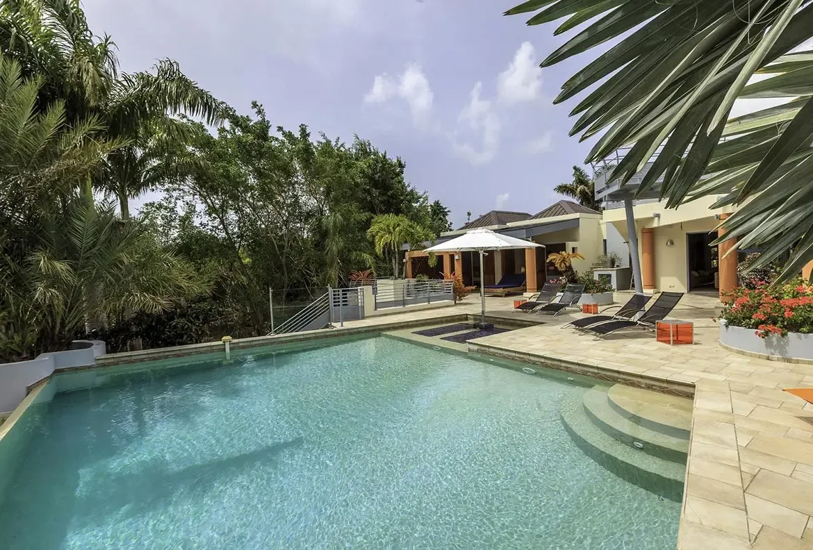Swim up to the edge of paradise — your infinity pool overlooking lush tropical gardens.