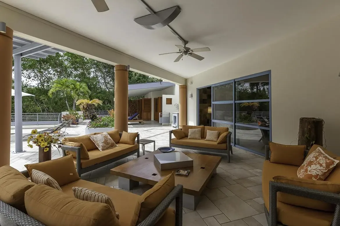Pool deck with umbrellas surrounded by lush landscaping.
