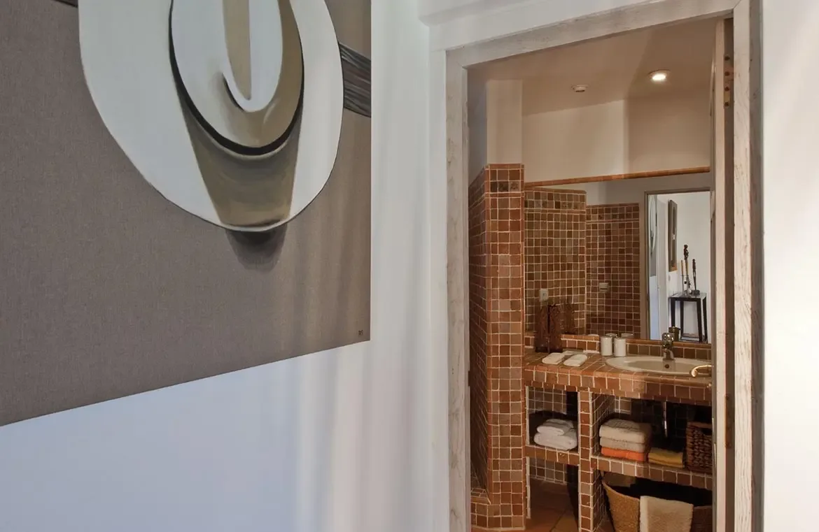 Modern ensuite with terracotta mosaic tiles and artistic touches.