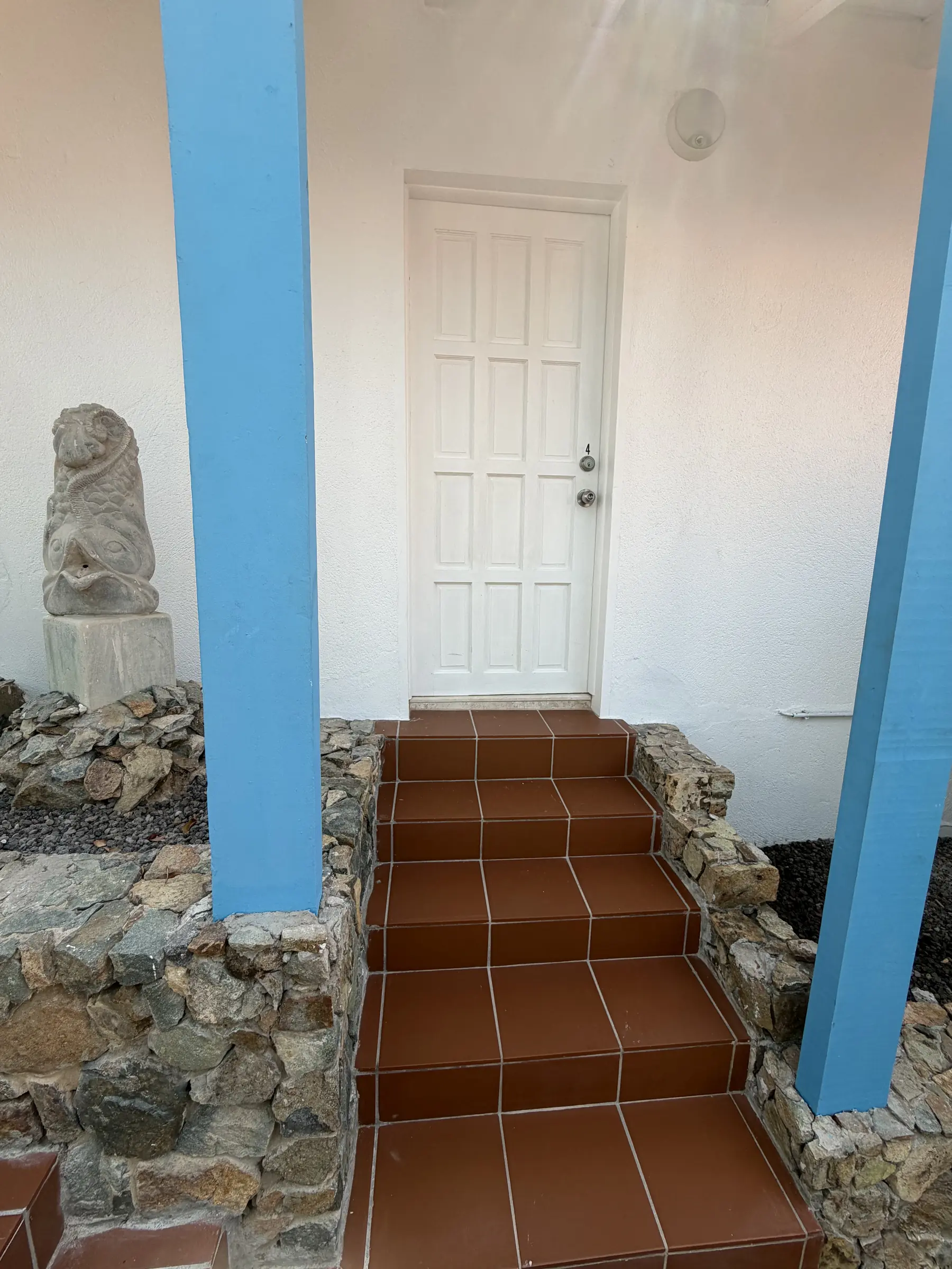 Blue columns and terracotta steps mark the private entrance to Bedroom 4.