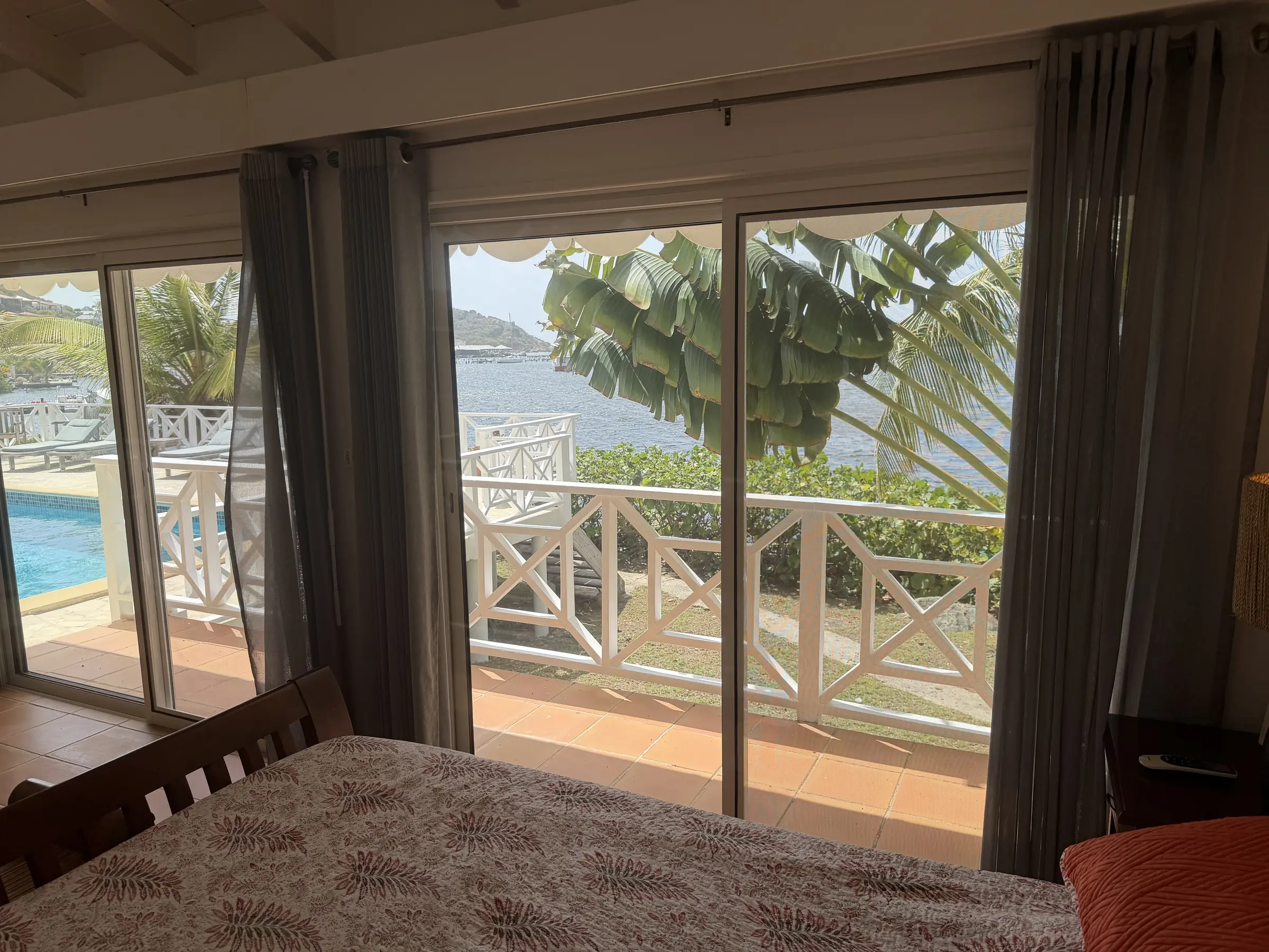 Bedroom 1 opens to a private balcony overlooking the water.