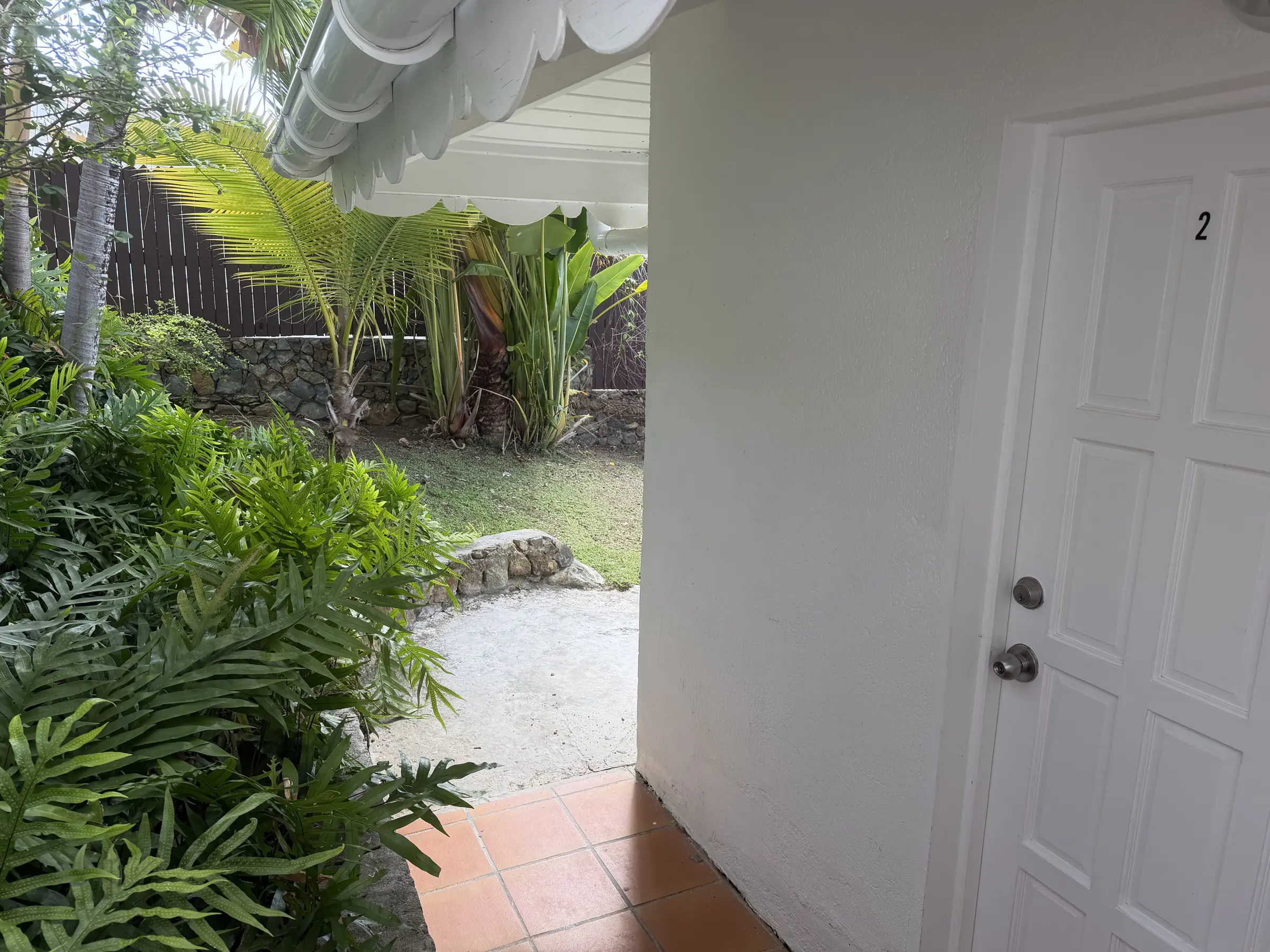 Bedroom 2 has a private entrance surrounded by tropical greenery.