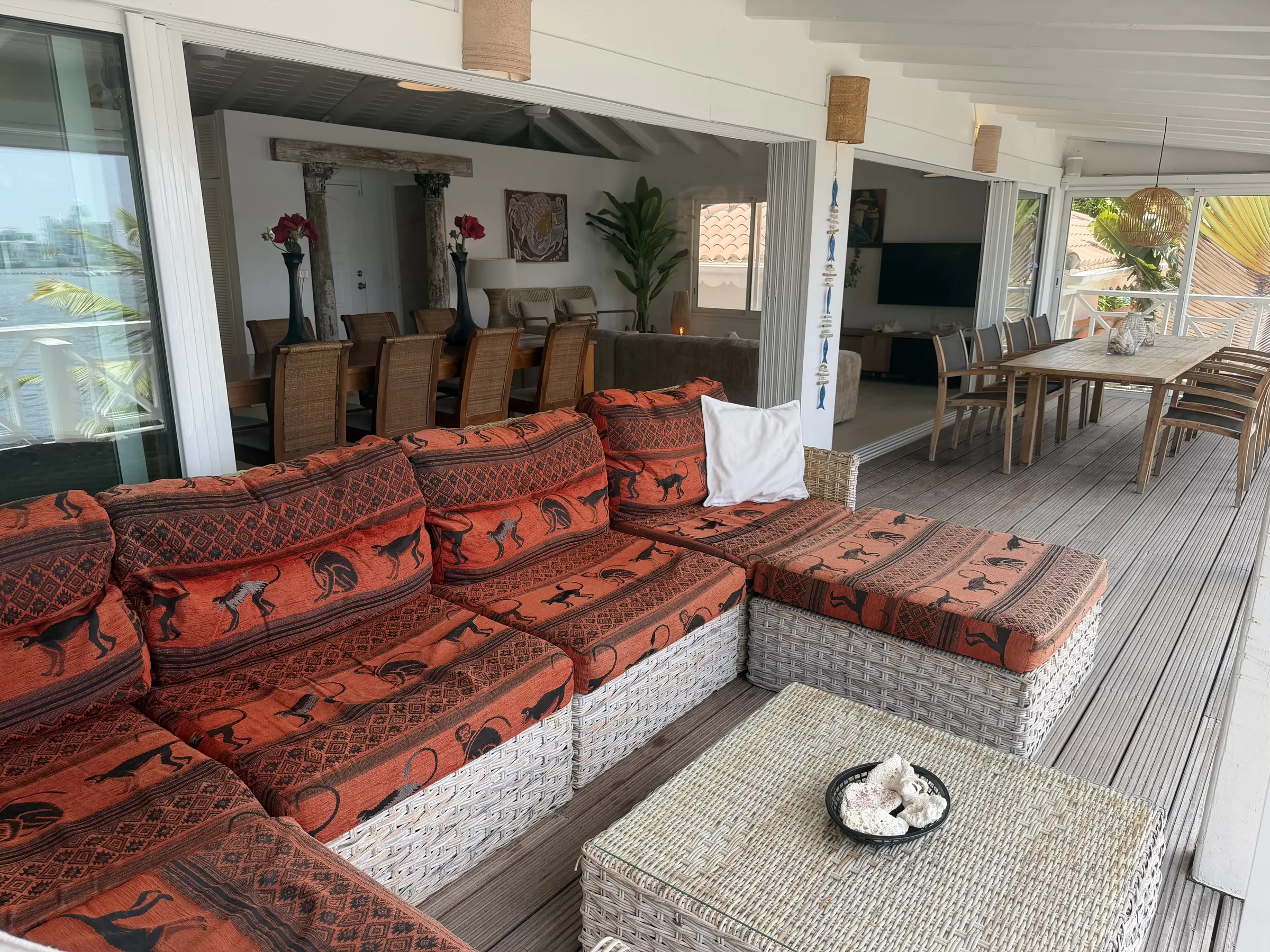 Covered outdoor lounge beside the villa's waterfront living spaces.
