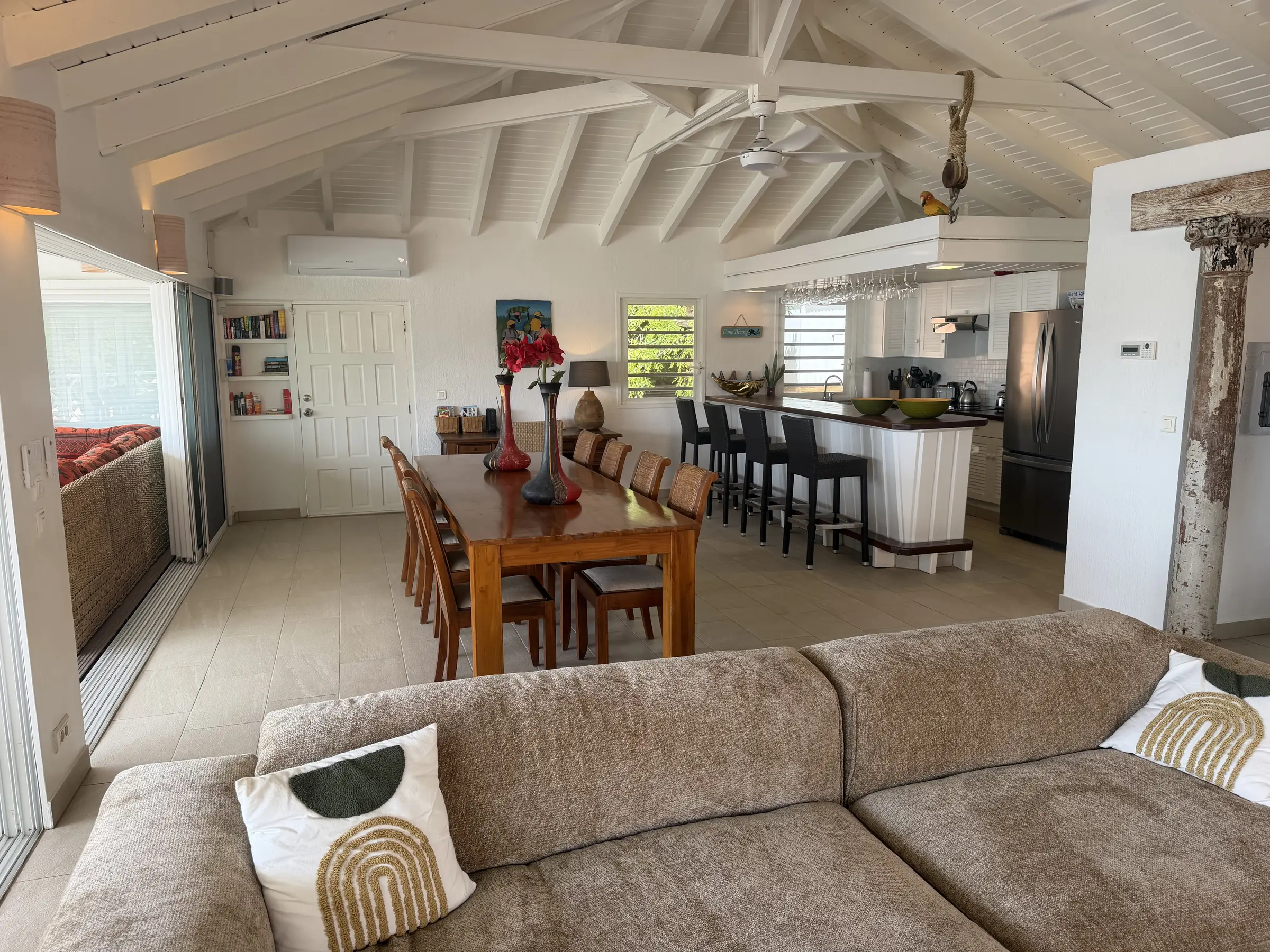 Bright living, dining, and kitchen spaces beneath white vaulted ceilings.