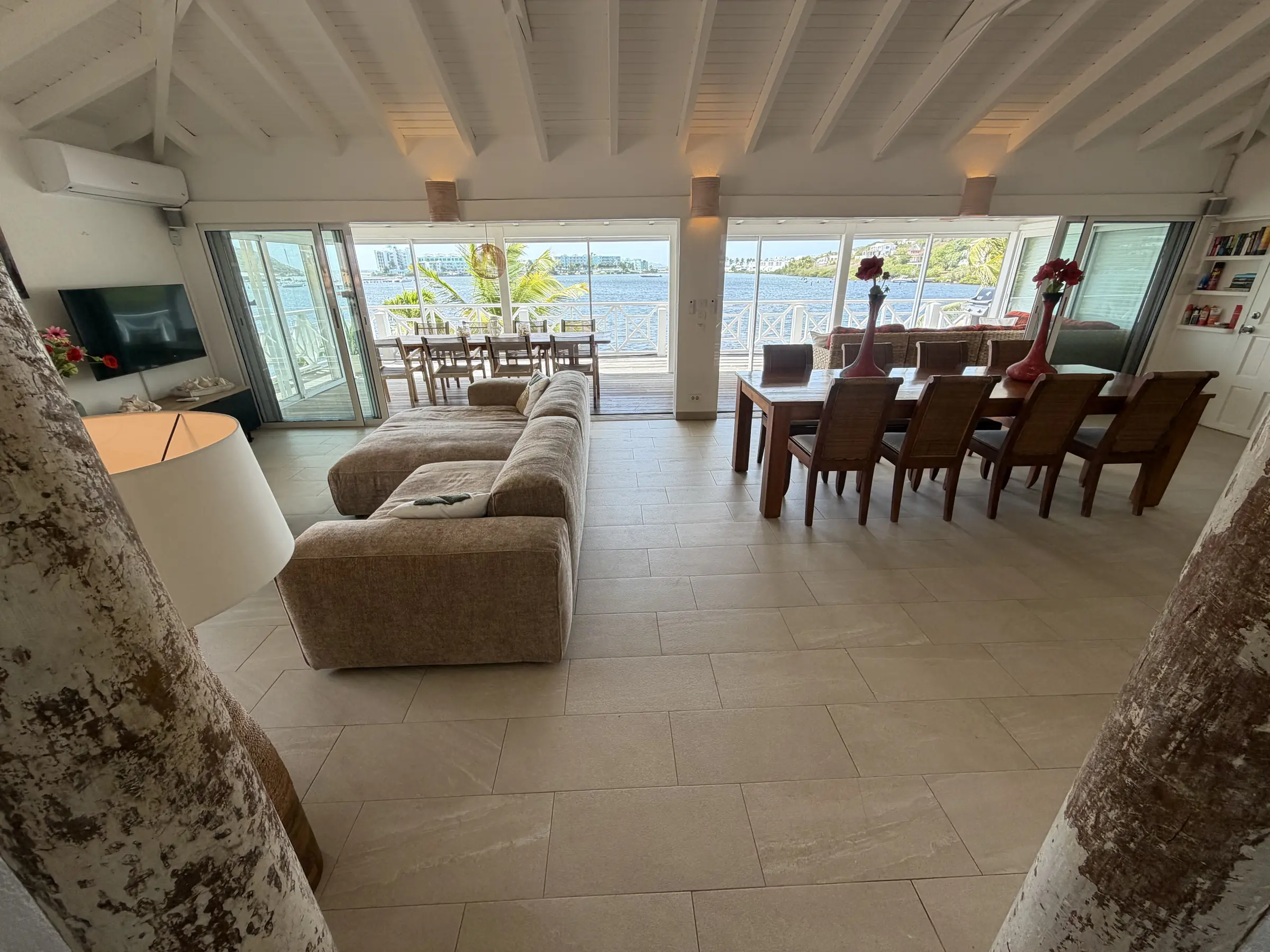 Open-plan living and dining area with lagoon views through wide glass doors.