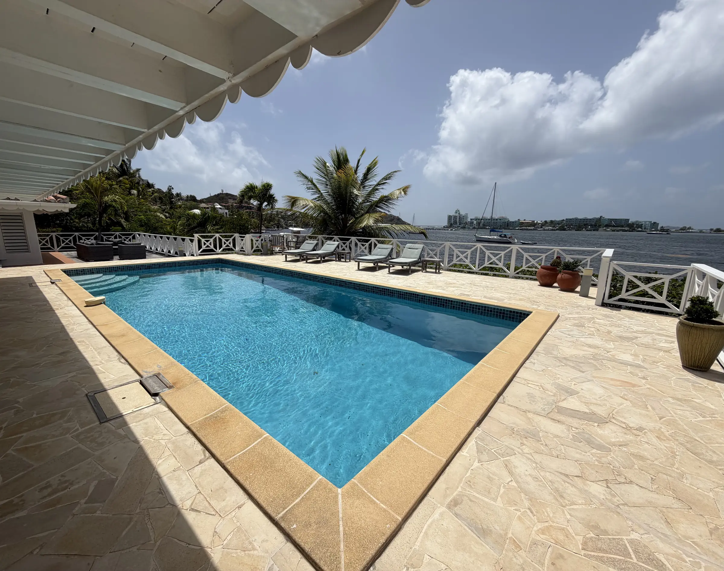 The private pool overlooks the lagoon and surrounding tropical landscape.