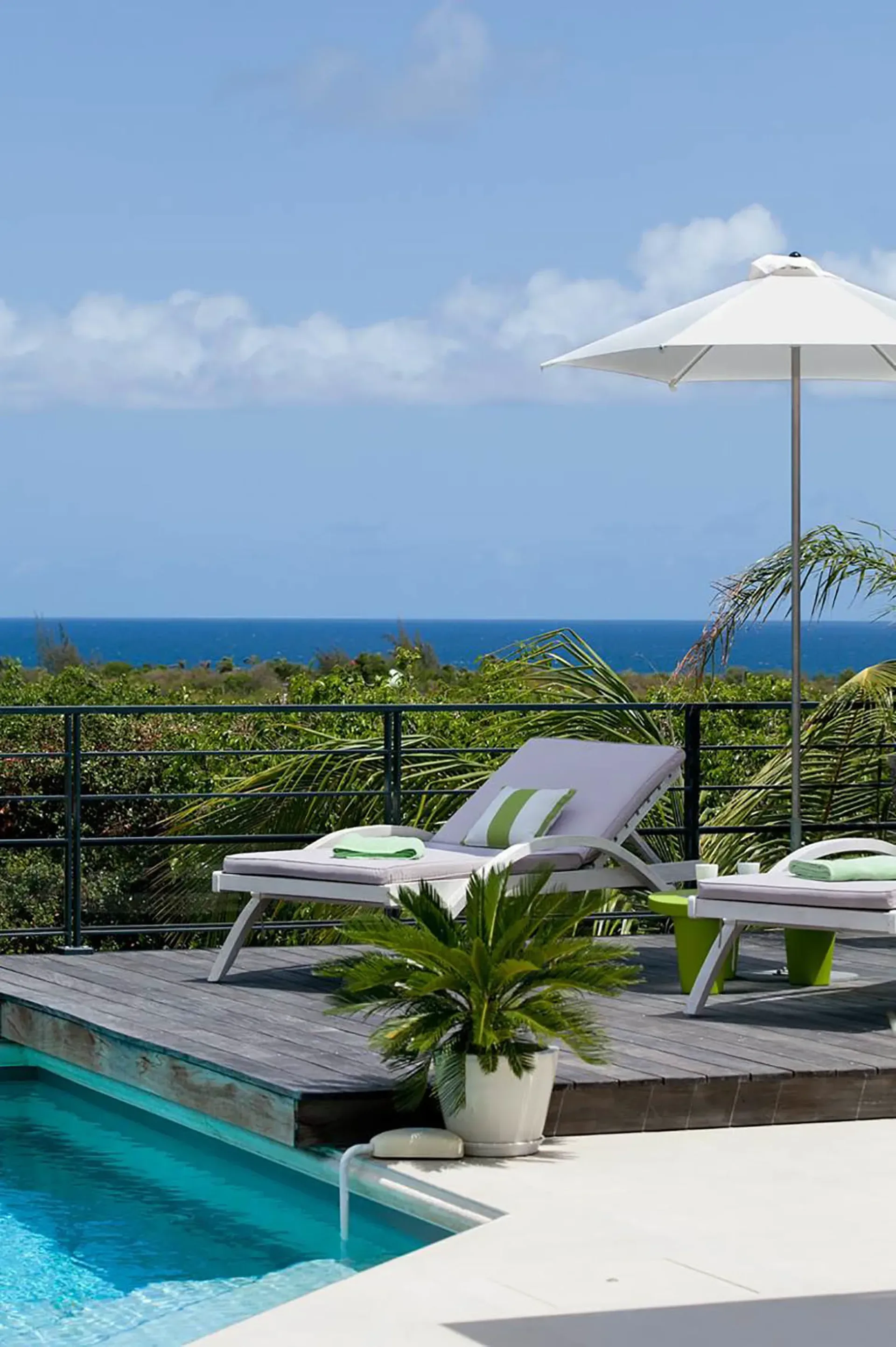 Elevated deck with loungers and panoramic sea views.