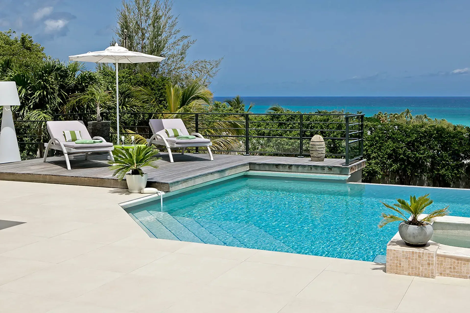 Elevated deck with panoramic ocean and pool views.