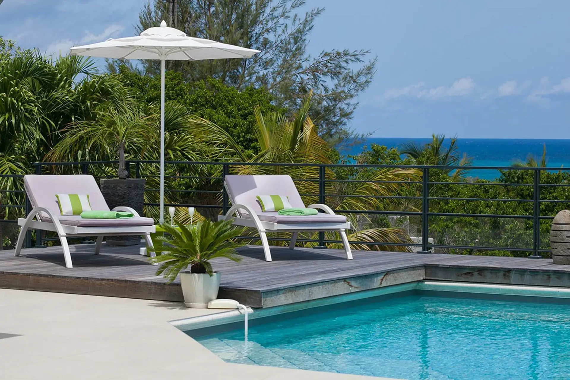 Sun deck with umbrella and tropical sea views.
